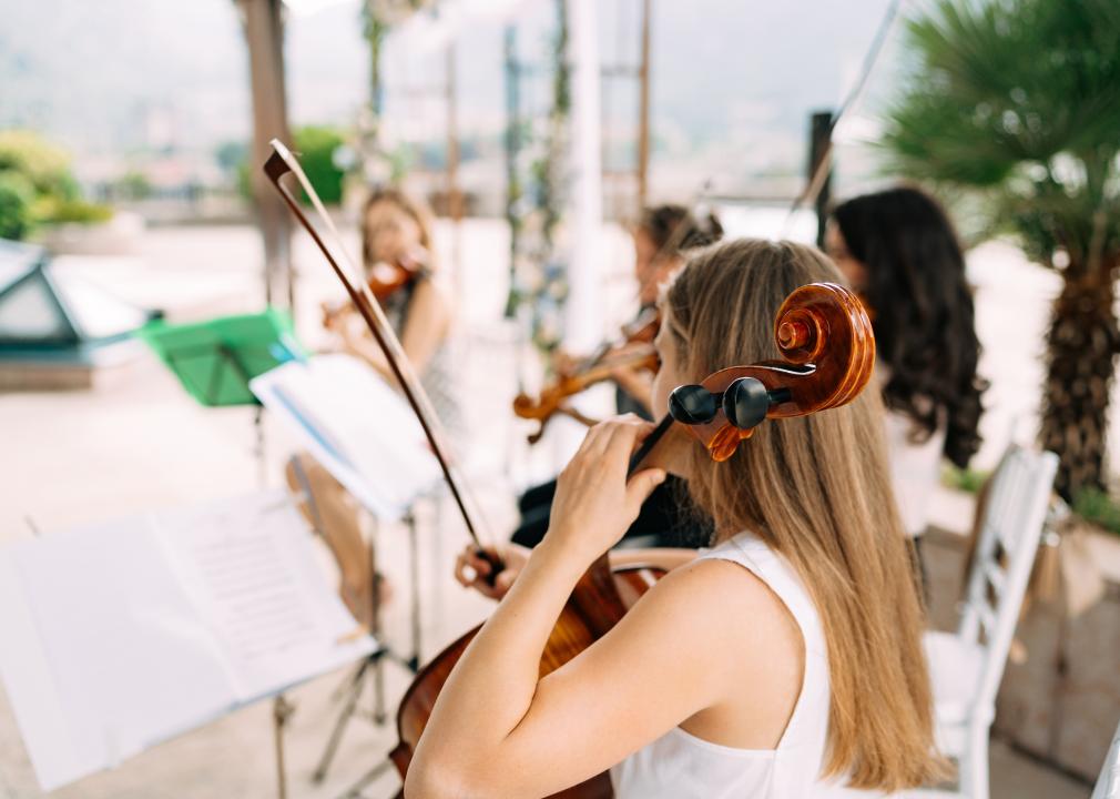 Back view of female musician playing a cello 