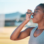 A woman using an inhaler.