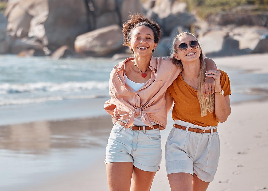 A happy lesbian couple walking on the beach.