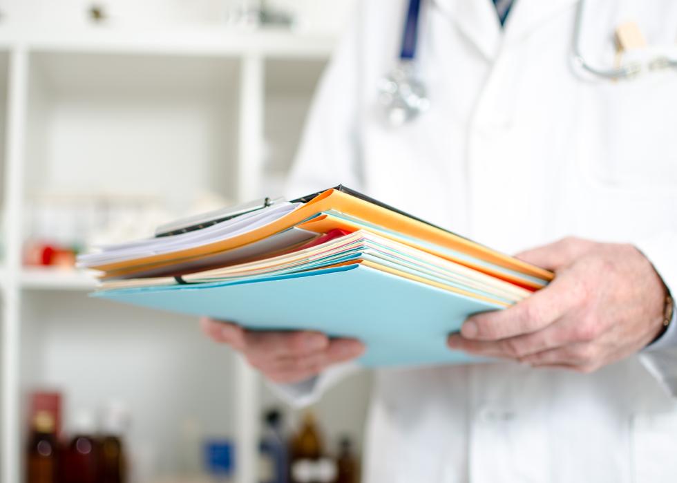 Doctor holding files in his office.